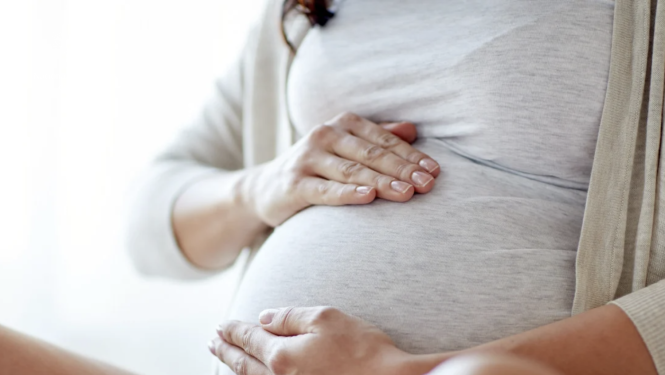 Pregnant woman holding her hand on her stomach