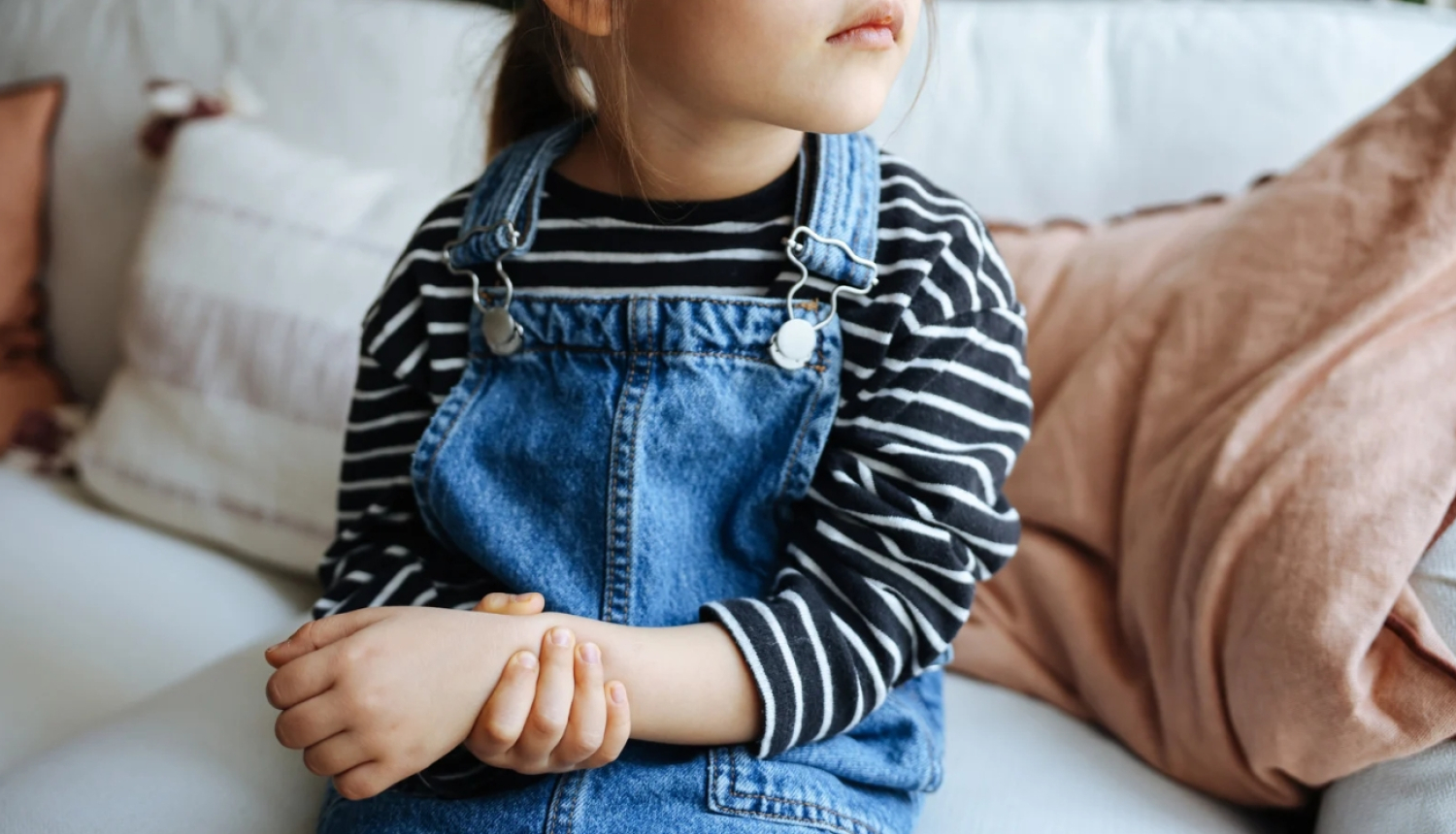 Maza meitenīte tur savu sāpošo roku